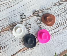 three different colored hats are hanging from the side of a white wooden table with stars on it