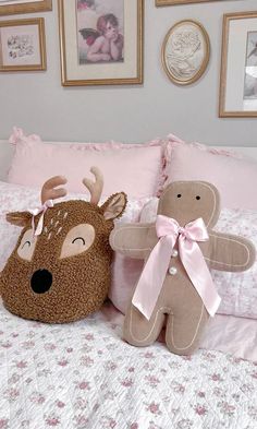 two stuffed animals sitting on top of a bed next to pillows and pictures above them