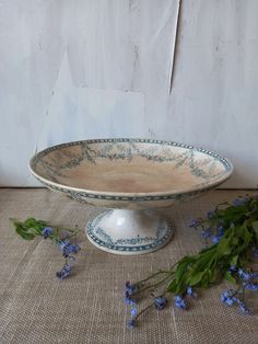 a white bowl with blue flowers sitting on top of a table