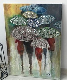 a painting with many umbrellas on it next to a candle and some vases