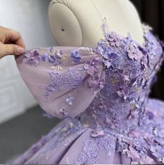 An exquisite Purple Quinceanera Gown graces the figure with a voluminous skirt of floral embellishments, a delicate hemline adorned with an intricate motif, and showstopping off-the-shoulder cuffs; further accentuated with an opulent oversized bow and ribbon lacing in back for a perfect fit. material: organza color: as shown type: party ball gown sweetheart neckline built in bra lace up back shown as size 2 original photos Purple Aesthetic Quince Dress, Quinceanera Purple Theme, Lilac Quinceanera Dresses, Quinceanera Themes Dresses, Princess Evening Dress, Purple Quinceanera Dresses, Diy Outfits, Purple Evening Dress, Quinceanera Dresses Pink