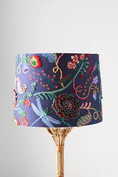 a lamp that is sitting on top of a wooden table with a blue lampshade