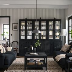 a living room with two couches and a coffee table in front of a bookcase