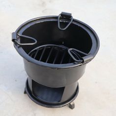 an outdoor grill with the lid open on top of it, sitting on a white surface