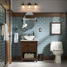 a bathroom with a toilet, sink and mirror on the wall in front of it