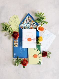 the wedding stationery is laid out on top of each other with flowers and cards