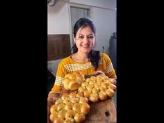 a woman holding a tray full of rolls