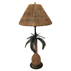 a table lamp with a palm tree on it's base and a woven shade