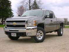 a silver truck parked on top of a dirt field