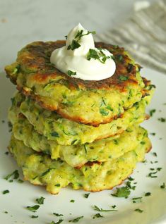 a stack of crab cakes with sour cream on top