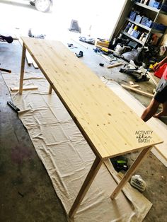 a man working on a wooden table in a garage