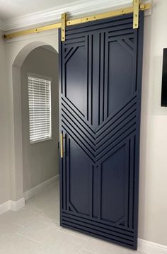 an open blue door in the middle of a room with white tile flooring and walls