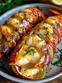 lobster wrapped in cheese and garnished with parsley on a plate next to carrots