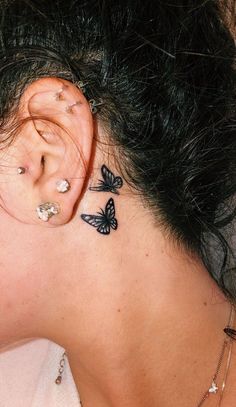 a woman with butterfly tattoos on her ear