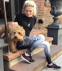 a woman sitting on the steps with her dog