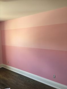 an empty room with pink and white paint on the walls