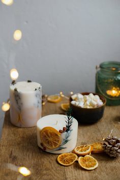 an assortment of orange slices and candles on a wooden table