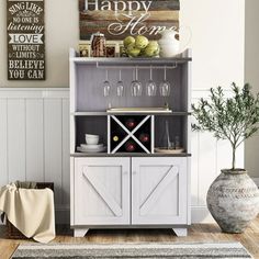 a white cabinet with wine glasses on it and a sign that says happy home above it