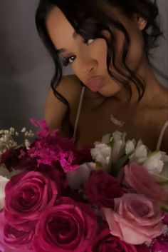 a woman holding a bouquet of flowers in front of her face