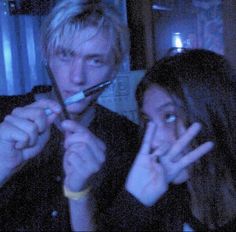 two people are brushing their teeth in the dark