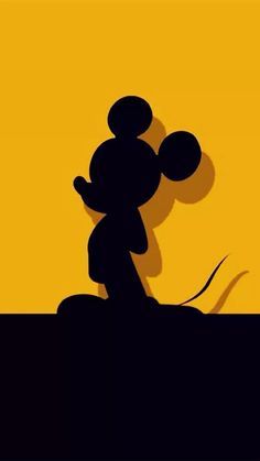 the shadow of mickey mouse on a yellow and black background is seen in this image