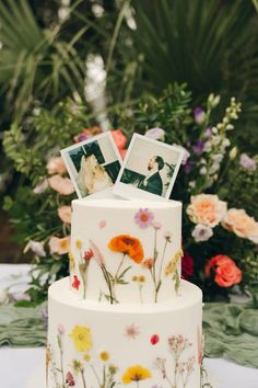 a wedding cake decorated with flowers and photos