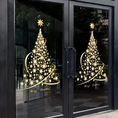 two glass windows with gold christmas trees on the front and side of them, both decorated with stars