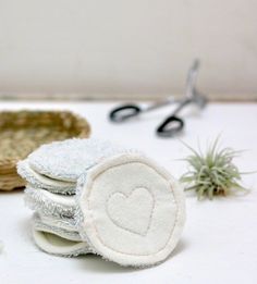 several pieces of cloth with a heart on them next to scissors and airplants