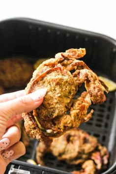 someone is holding up some fried food in their hand and it looks like they are eating something