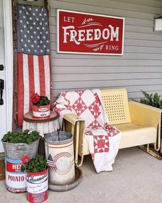 a porch with an american flag and potted plants