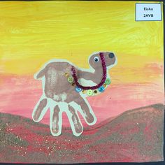 a child's hand painted with buttons and beads in the shape of a camel