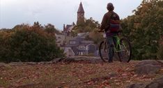 a man standing on top of a hill next to a bike