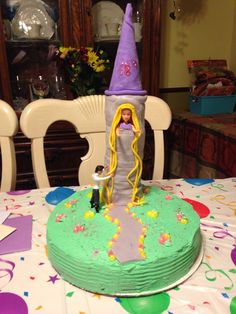 a birthday cake with a doll in the middle and a wizard's hat on top