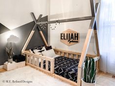 a child's bedroom with a teepee tent bed and black and white decor