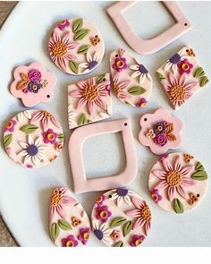 some pink and purple flowers are sitting on a white plate next to the letter d