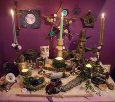 a table topped with lots of different types of items and candles on top of it