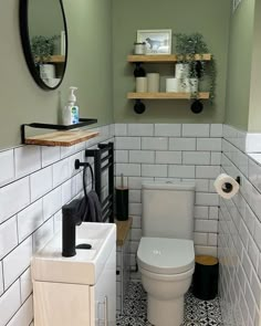 a white toilet sitting in a bathroom next to a sink