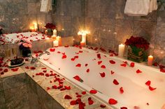 a bathtub filled with rose petals and candles