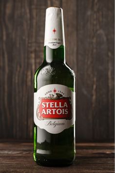 a bottle of beer sitting on top of a wooden table