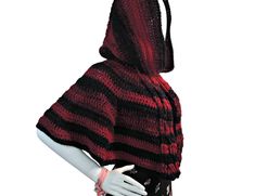 a mannequin wearing a red and black knitted hooded ponchy with hood