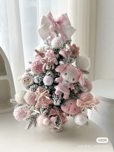 a small christmas tree decorated with pink and white teddy bears, snowflakes and bows