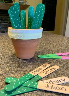 a potted plant sitting on top of a counter next to wooden utensils