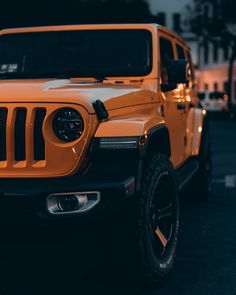 an orange jeep is parked on the street