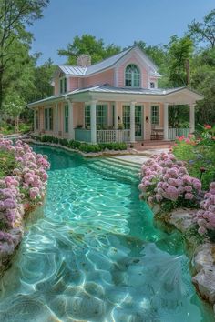 a pink house sitting on top of a lush green hillside next to a pool filled with water