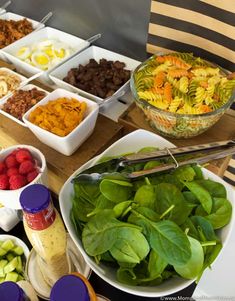 a table topped with lots of different types of food and salads on top of plates