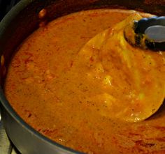 a ladle is being used to mix the sauce