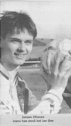 an old photo of a young man holding a baseball