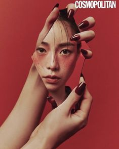 a woman holding her hair in front of her face with nails on top of her head