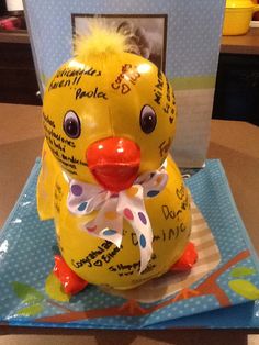 a yellow rubber ducky sitting on top of a blue and white plate with writing on it