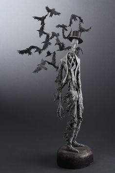 a sculpture of a man with many bats on his head and hands in the air